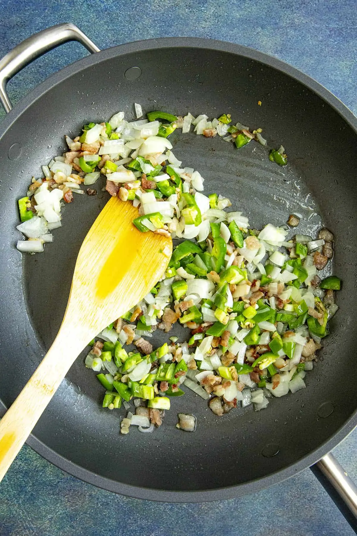 Cooking down onion and peppers in a pan to make charro beans