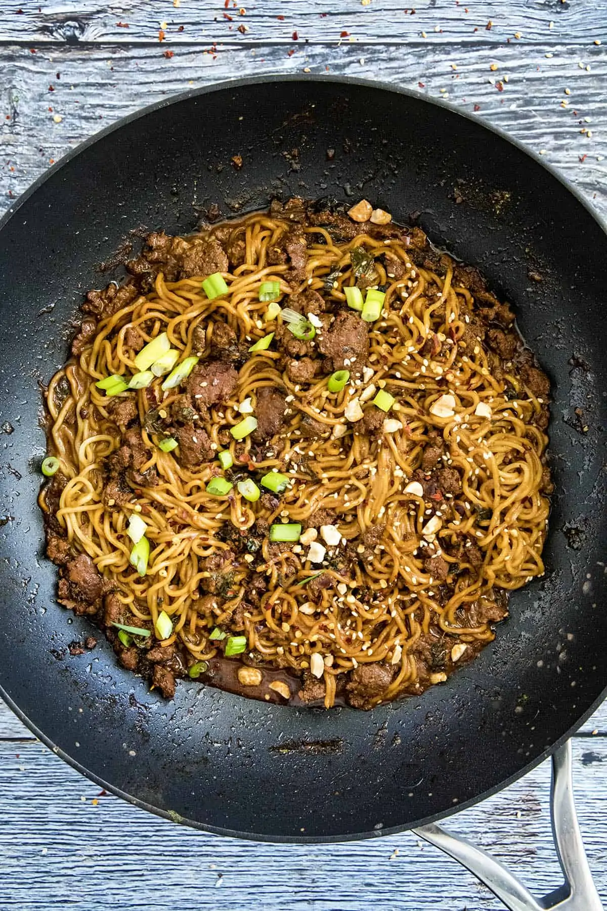 Dan Dan Noodles in a pan with garnish