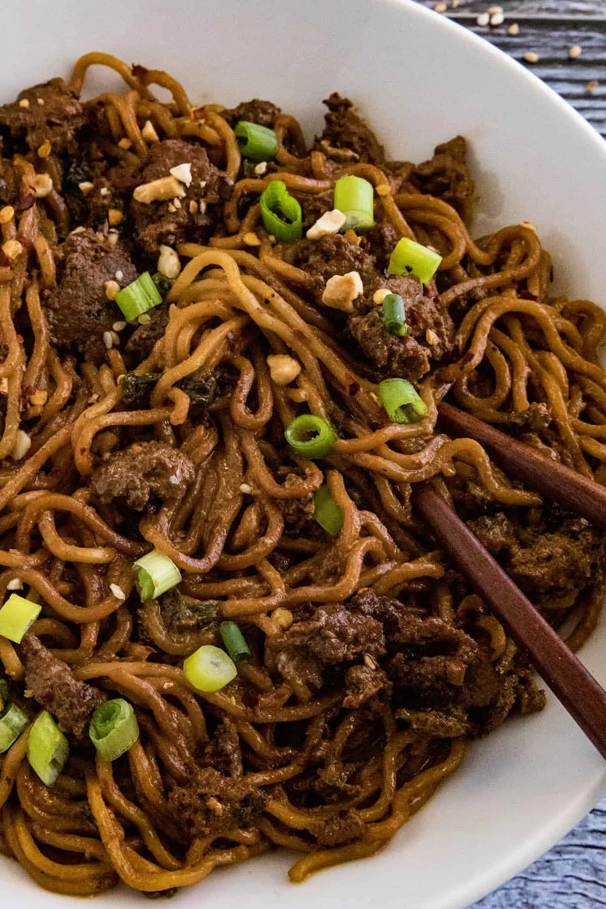 Dan Dan Noodles in a bowl with chopsticks, ready to eat