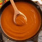 Mole Poblano served in a big dark bowl with a spoon inside.