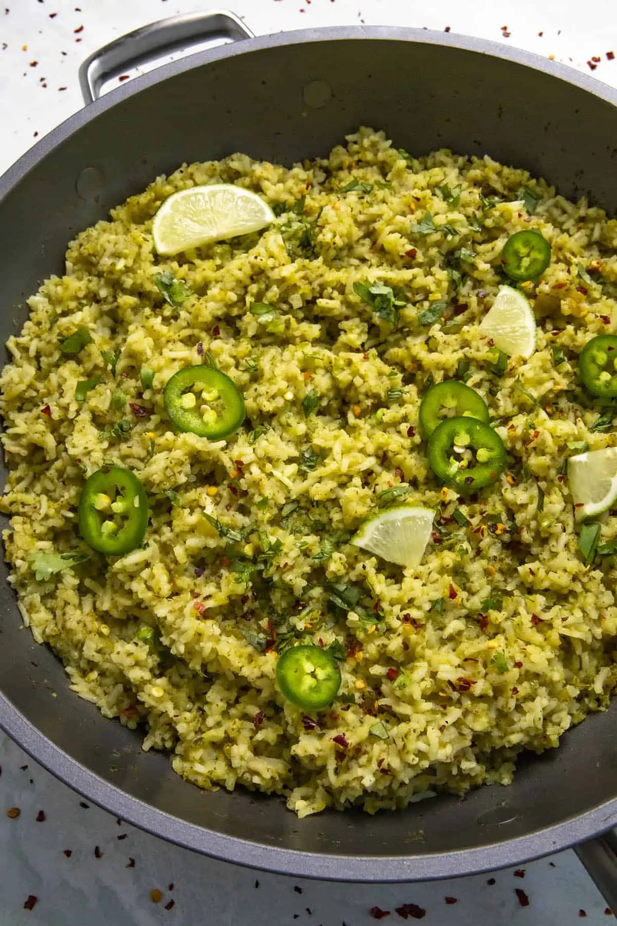 Arroz Verde in a hot pan with garnish.