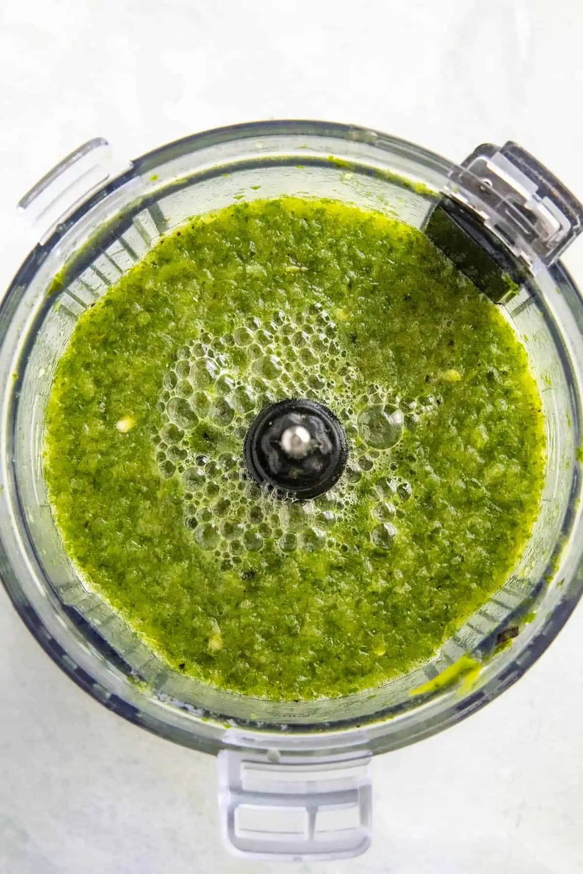 Pureed peppers and herbs in a food processor.