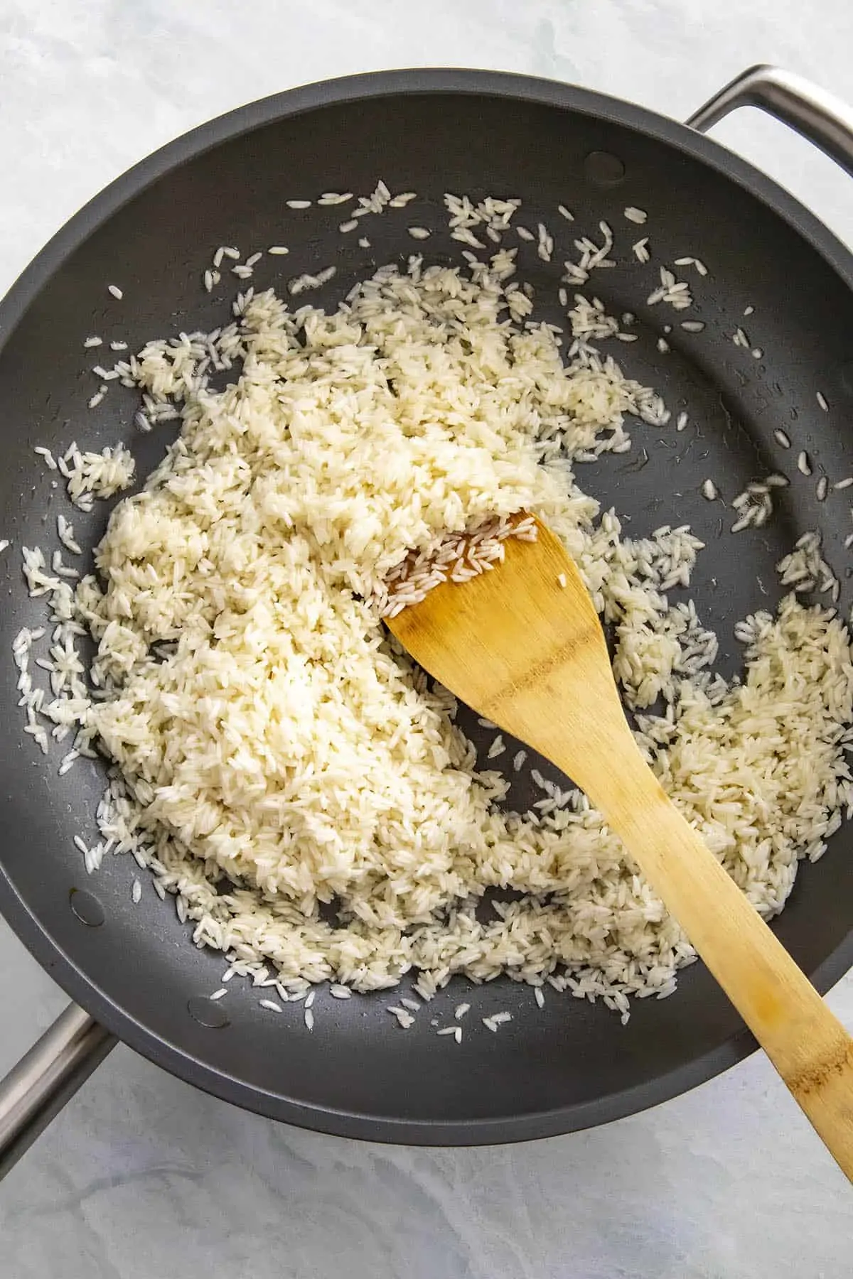Browning the rice to make arroz verde