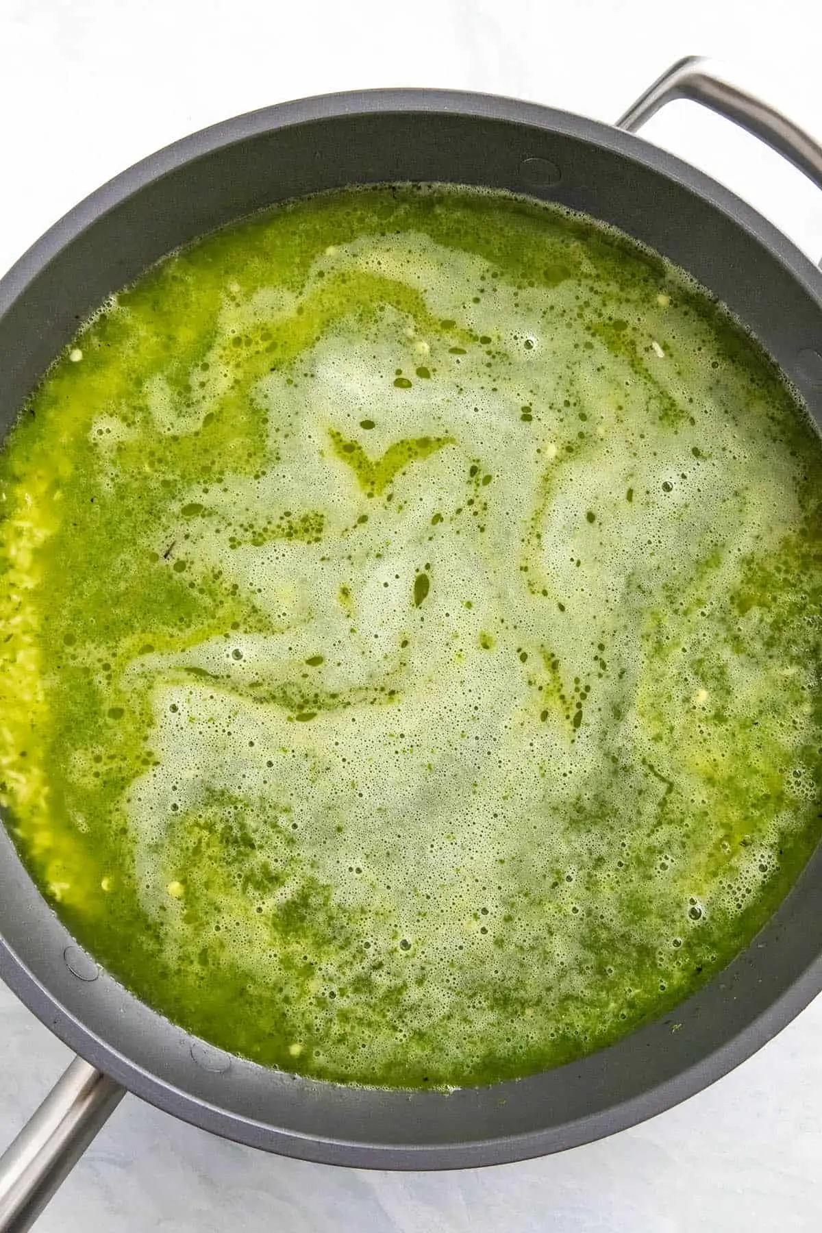 Simmering arroz verde in a pan.