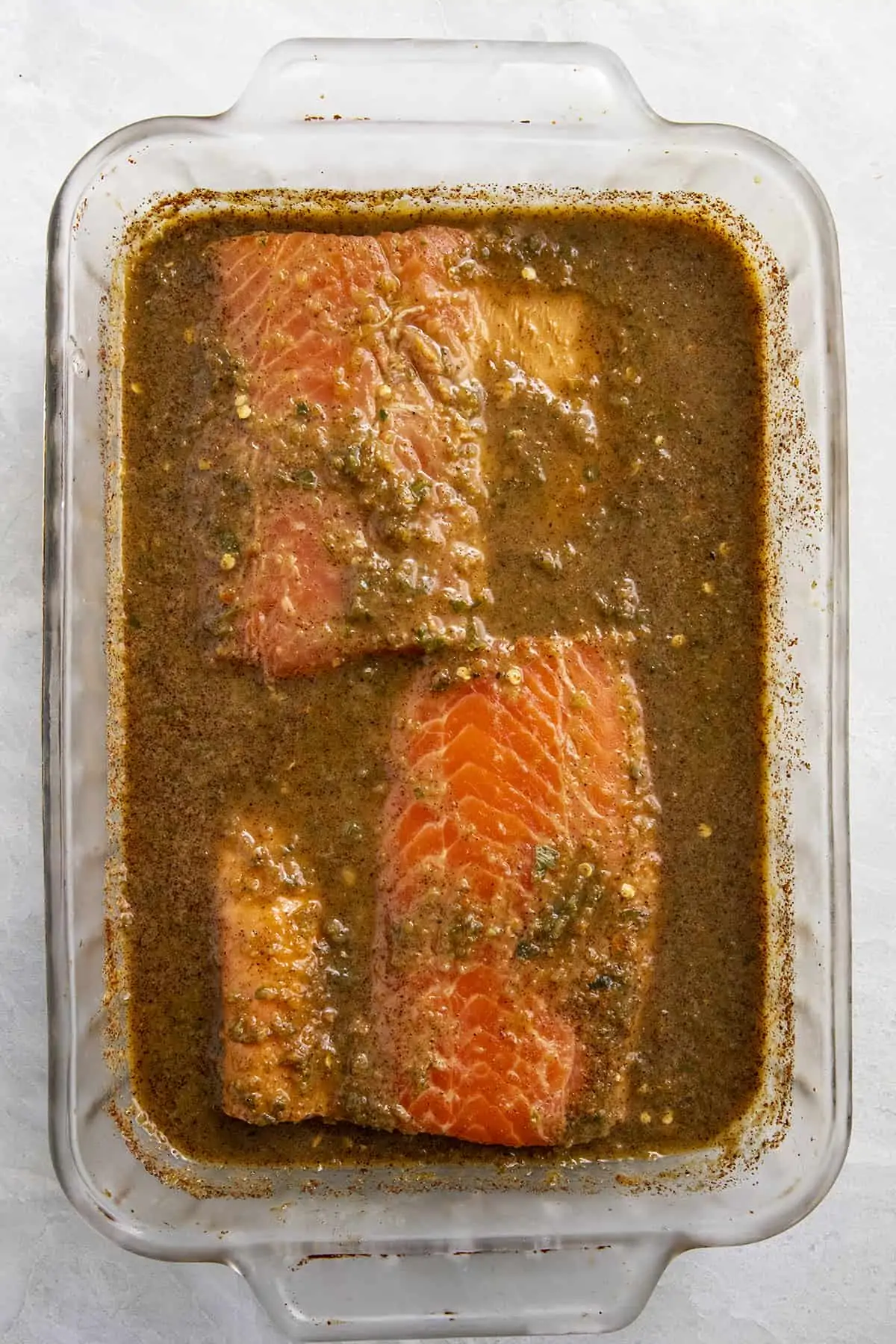 Jerk Salmon marinating in a spicy Jamaican jerk marinade.