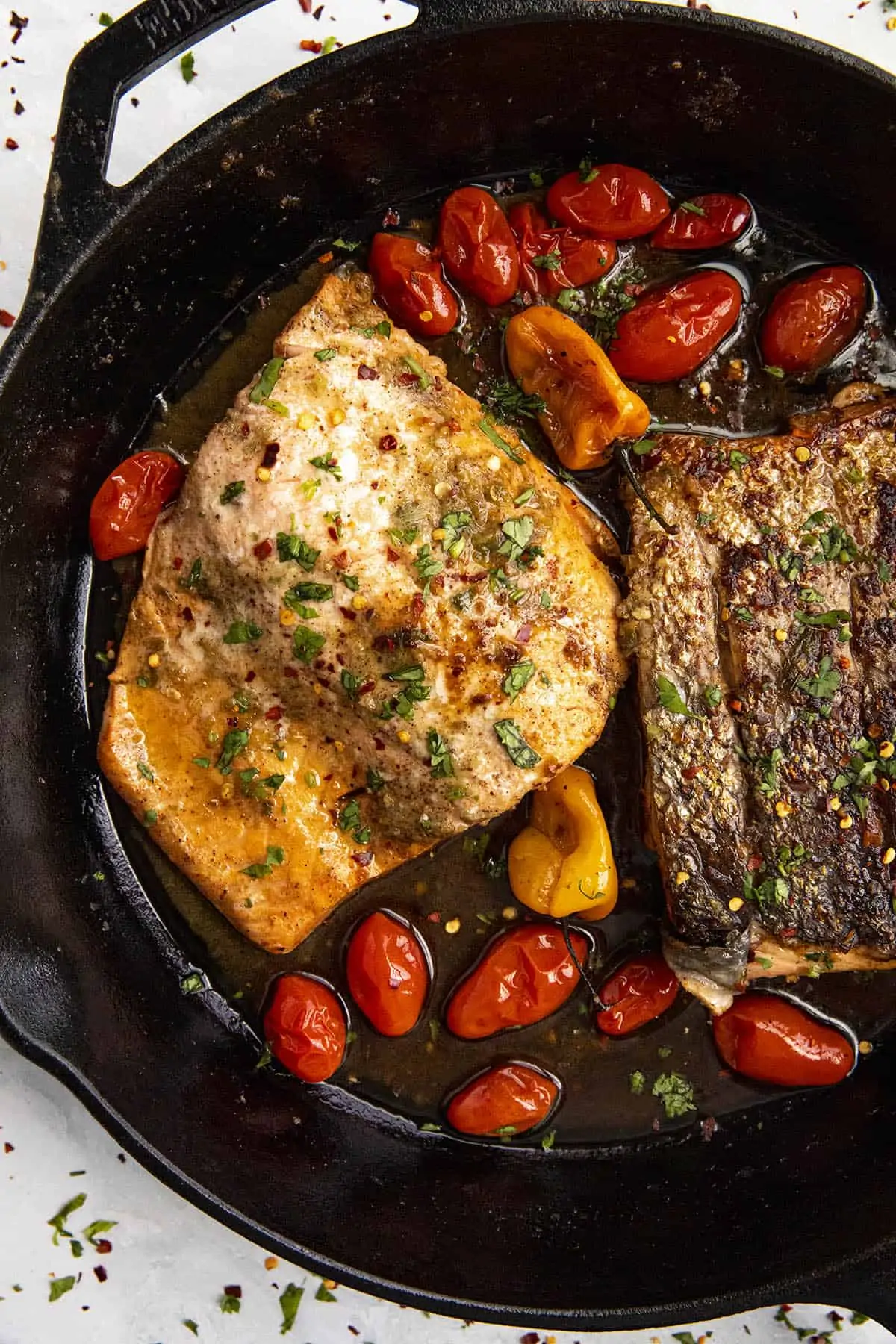 Two pieces of Jerk Salmon in a hot pan.