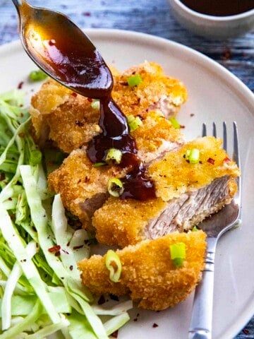 Pouring sauce on top of the Pork Katsu (Tonkatsu).