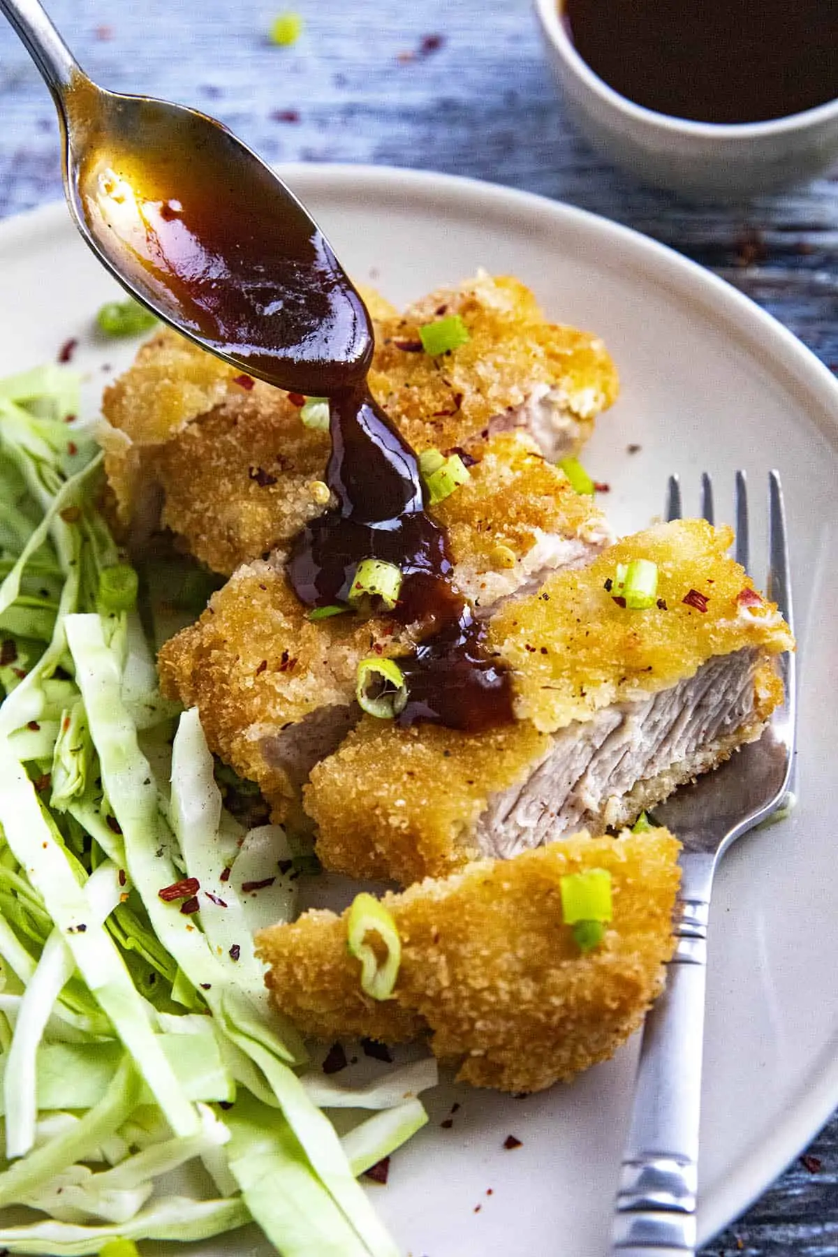 Pouring sauce on top of the Pork Katsu (Tonkatsu).