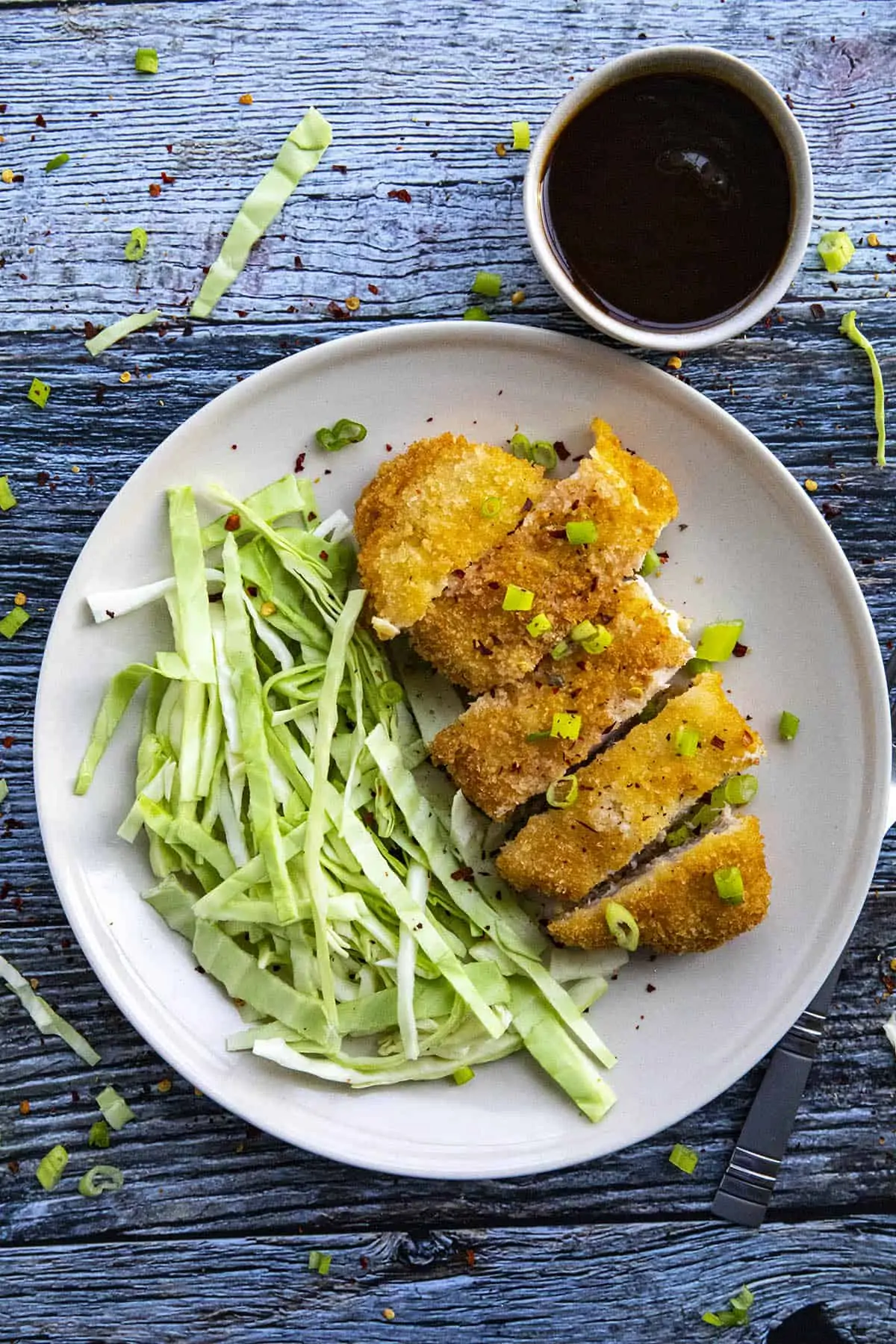 Sliced Pork Katsu on a plate with chopped cabbage.