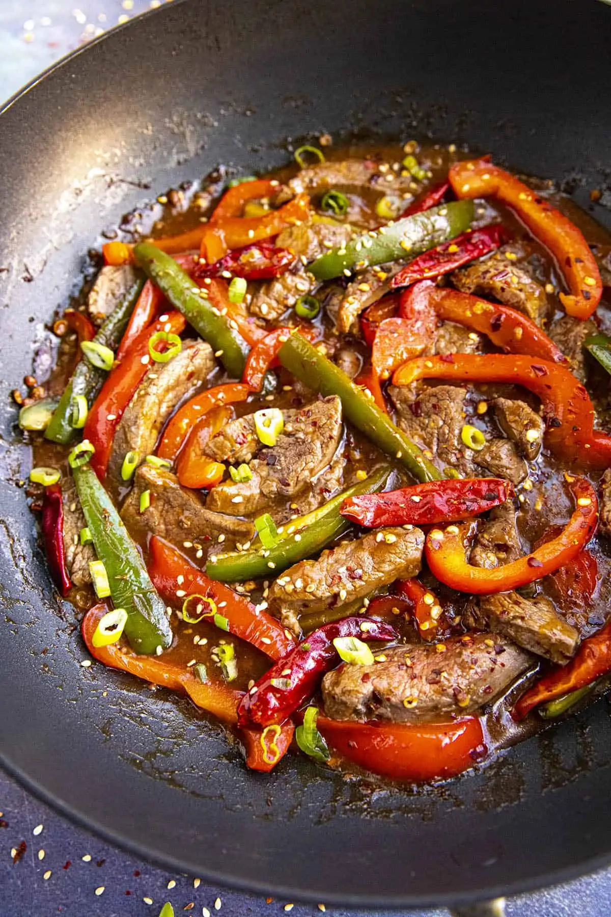 Szechuan Beef in a pan with lots of peppers