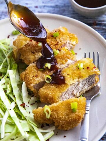 Pouring sauce on top of the Pork Katsu (Tonkatsu).