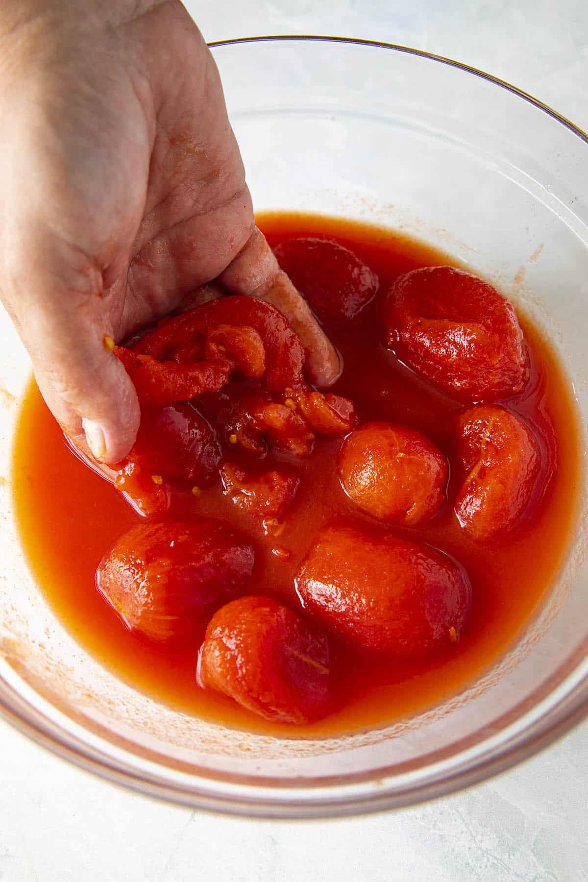 Crushing tomatoes to make Amatriciana sauce