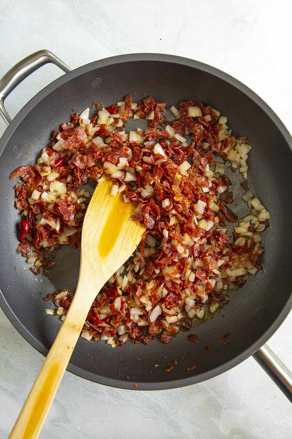 Cooking onions, peppers and guanciale to make Amatriciana sauce