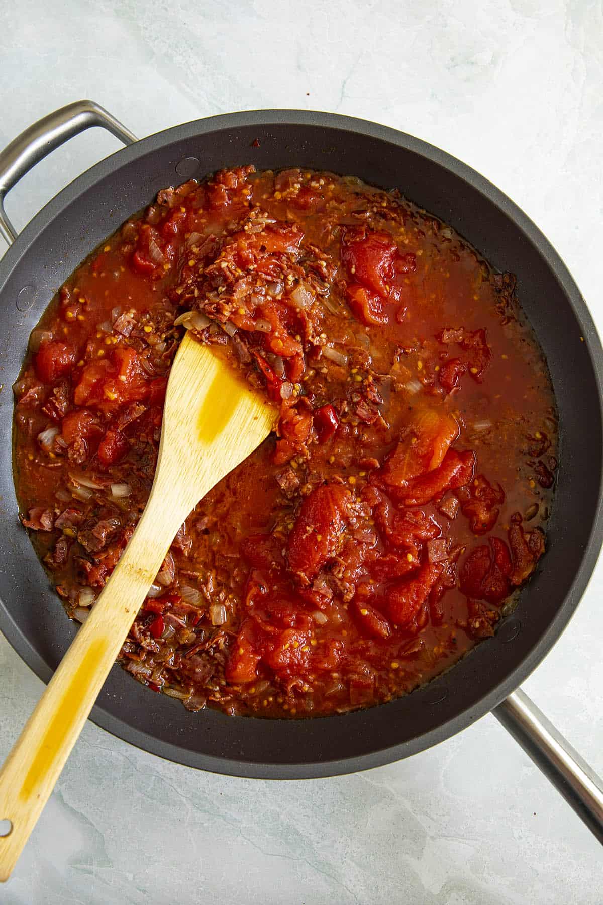 Stirring the Amatriciana sauce in a pan