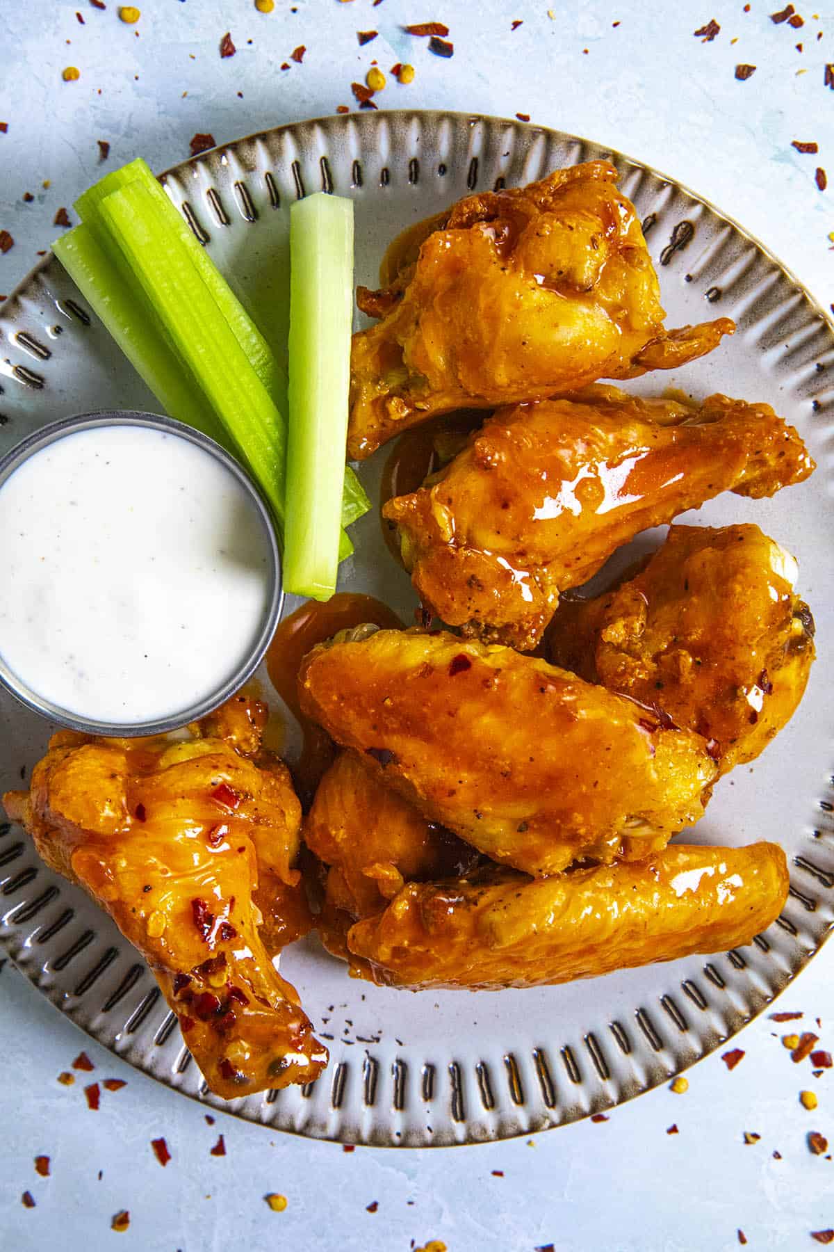 Buffalo Wings on a plate with dressing and celery sticks