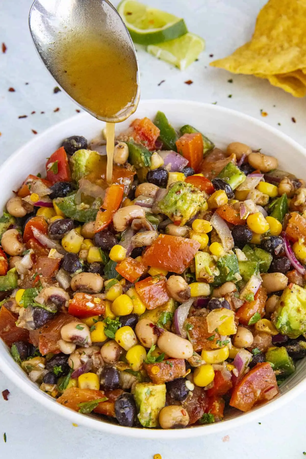 Adding more tangy vinaigrette to the Cowboy Caviar.