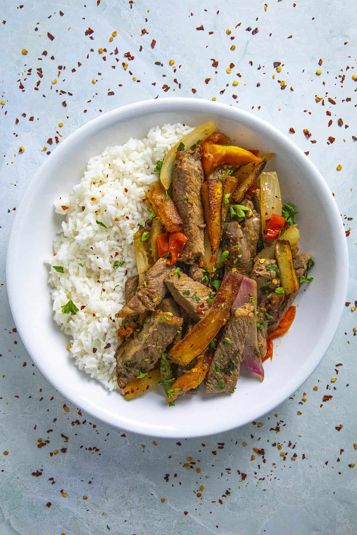 Peruvian Beef Stir Fry with French Fries (Lomo Saltado) in a bow over rice