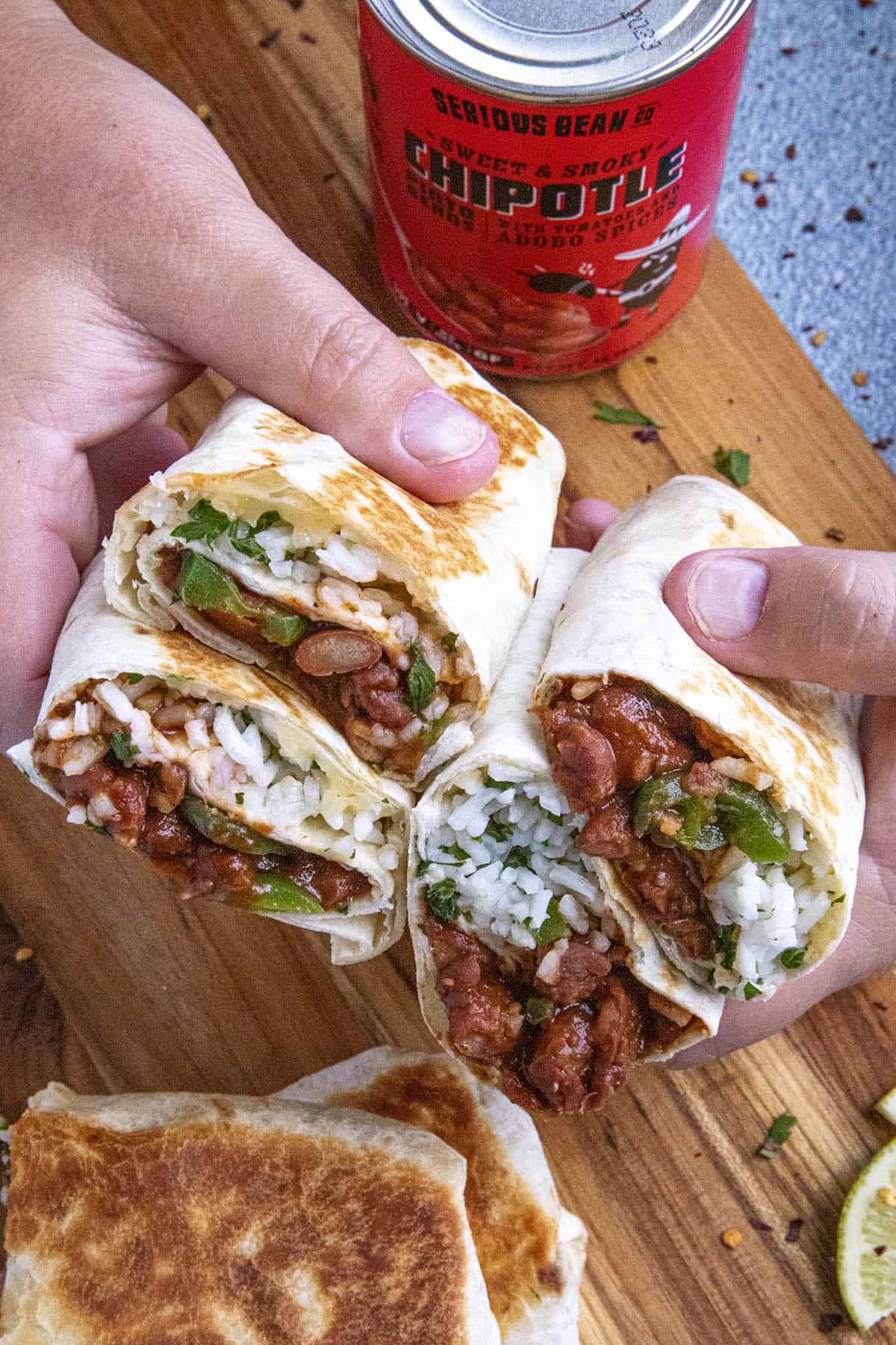 Mike holding bean burritos in two hands.