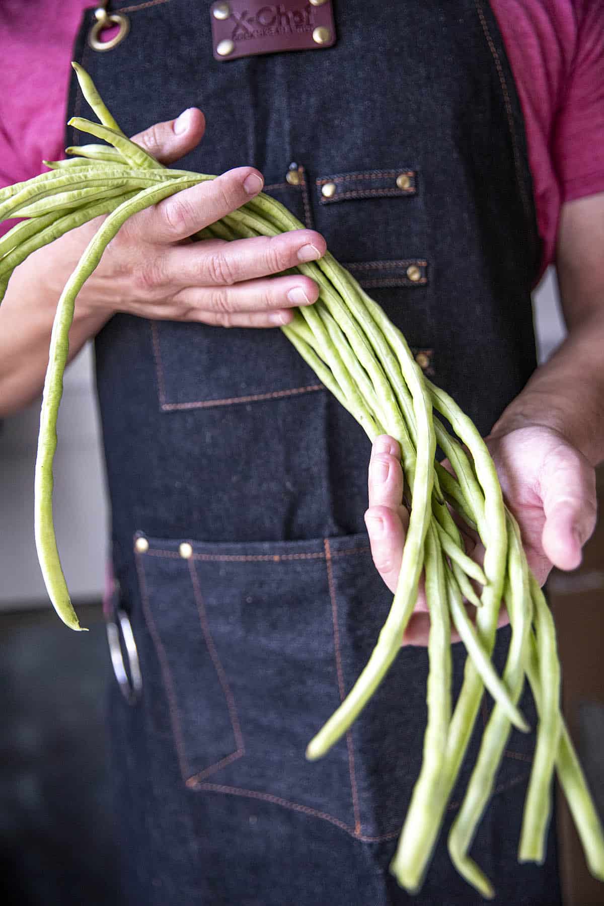 Mike holding a handful of long beans