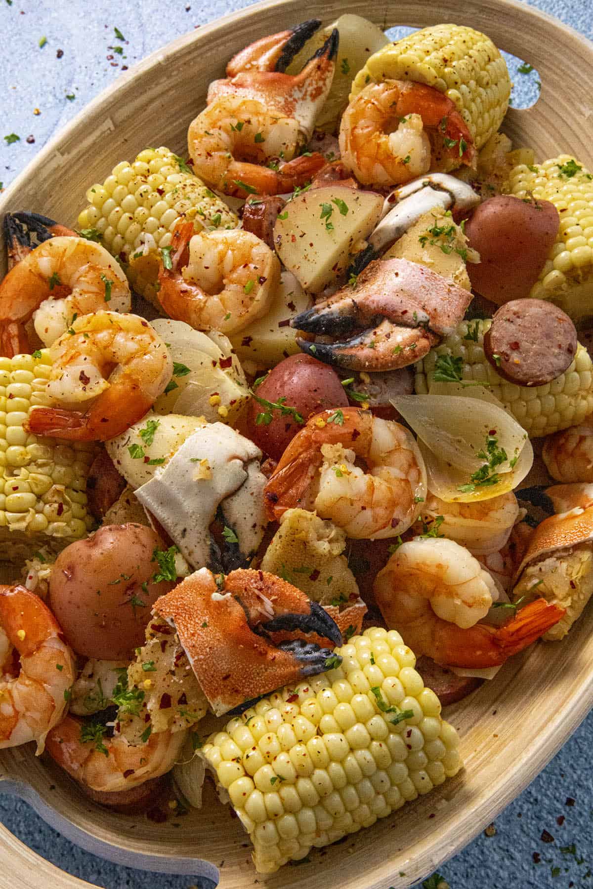 Low Country Boil in a platter with lots of boiled corn, shrimp, crab and smoked sausage