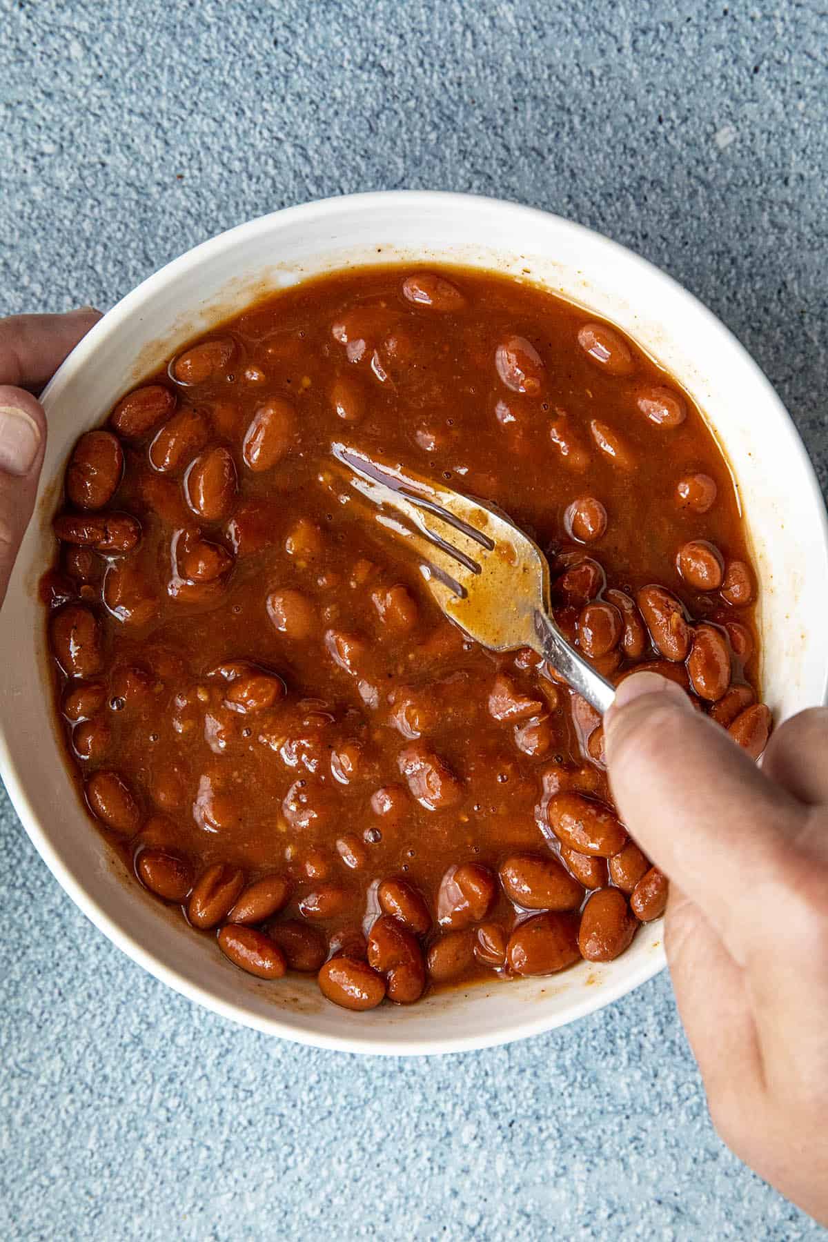 Mashing pinto beans to make a bean burrito.