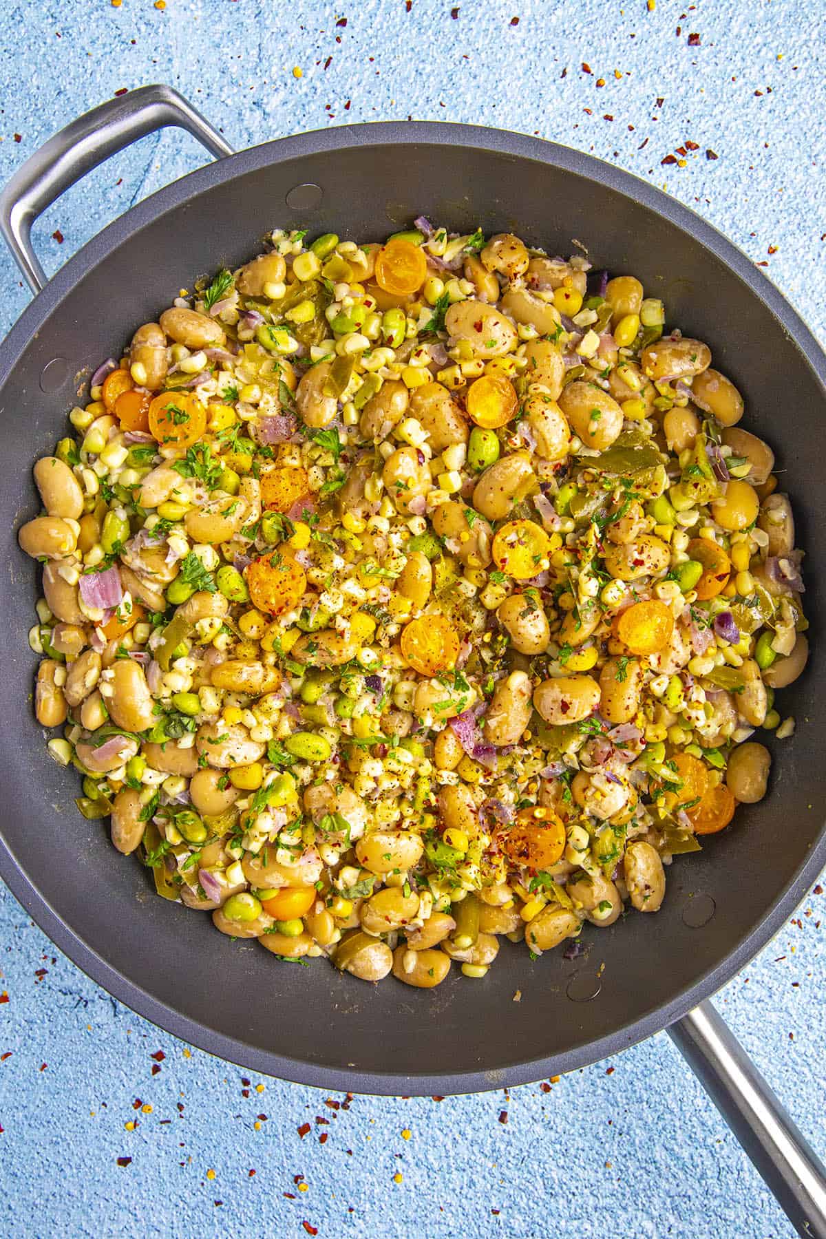 Butter bean succotash in a pan with garnish, ready to serve