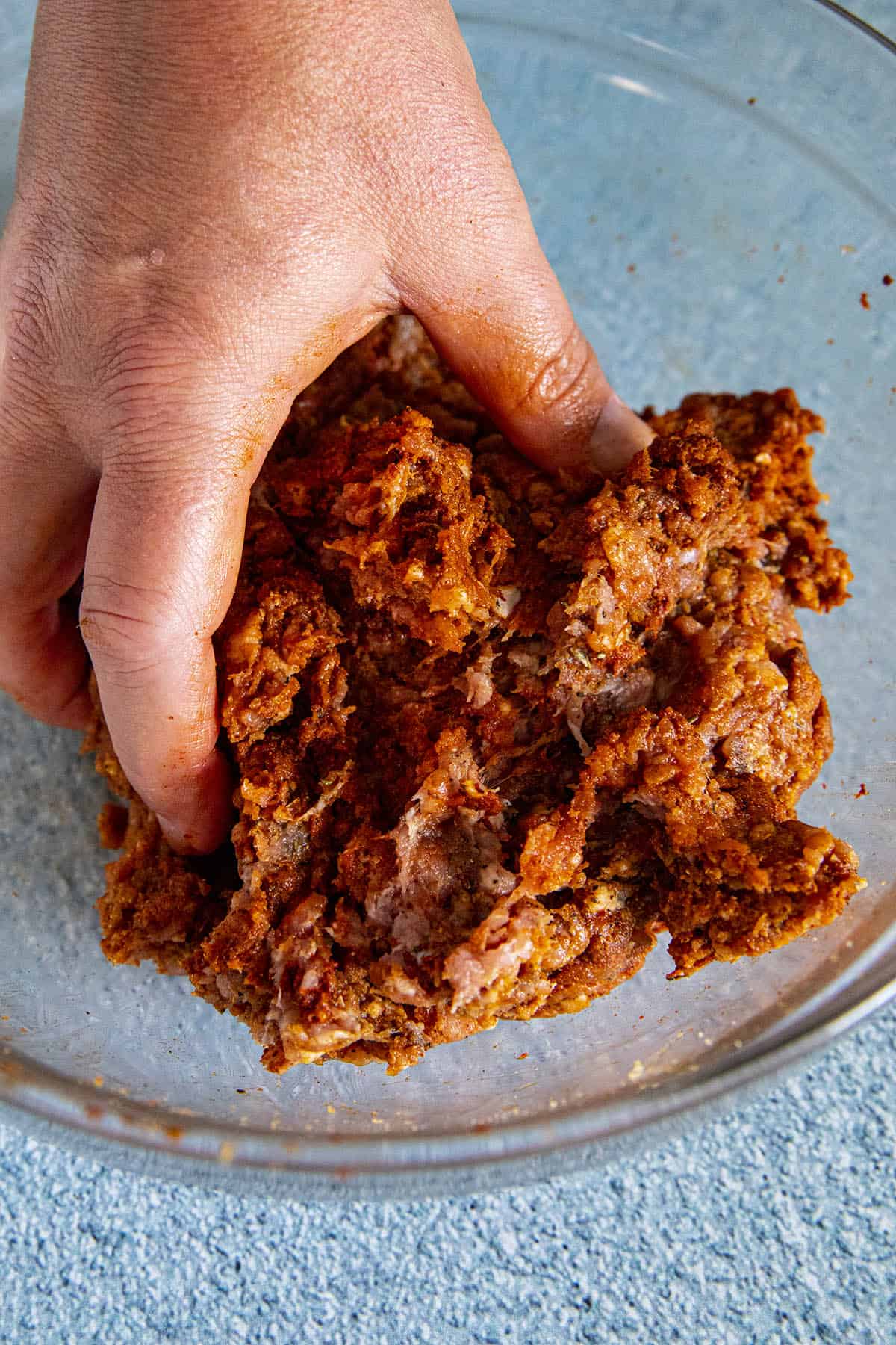 Mike hand mixing Homemade Mexican Chorizo in a bowl