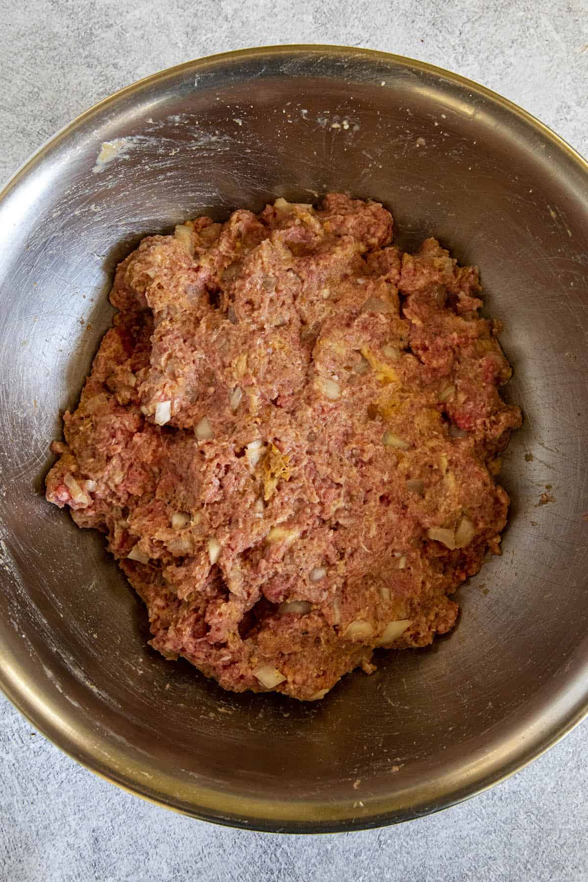 Hand mixing meatballs to make Albondigas