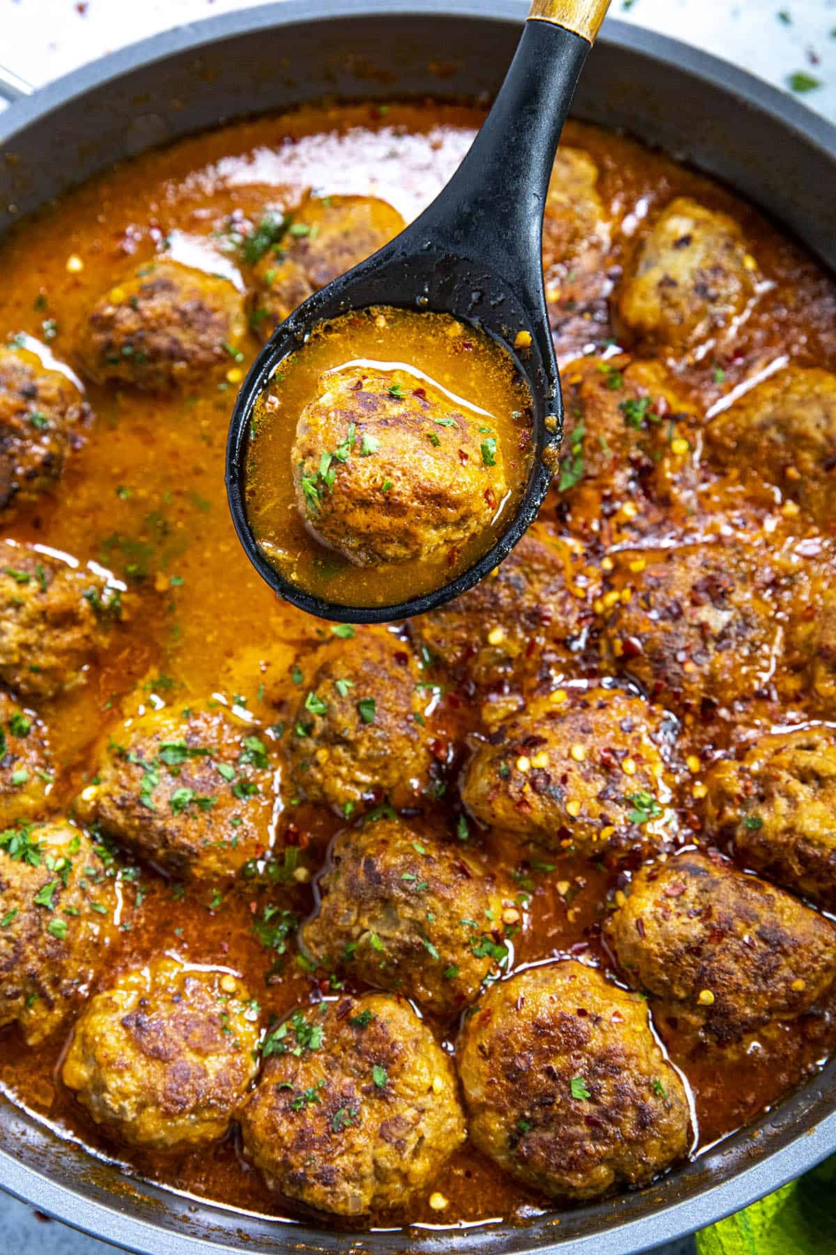 Serving a Mexican meatball (Albondigas) from the hot pan
