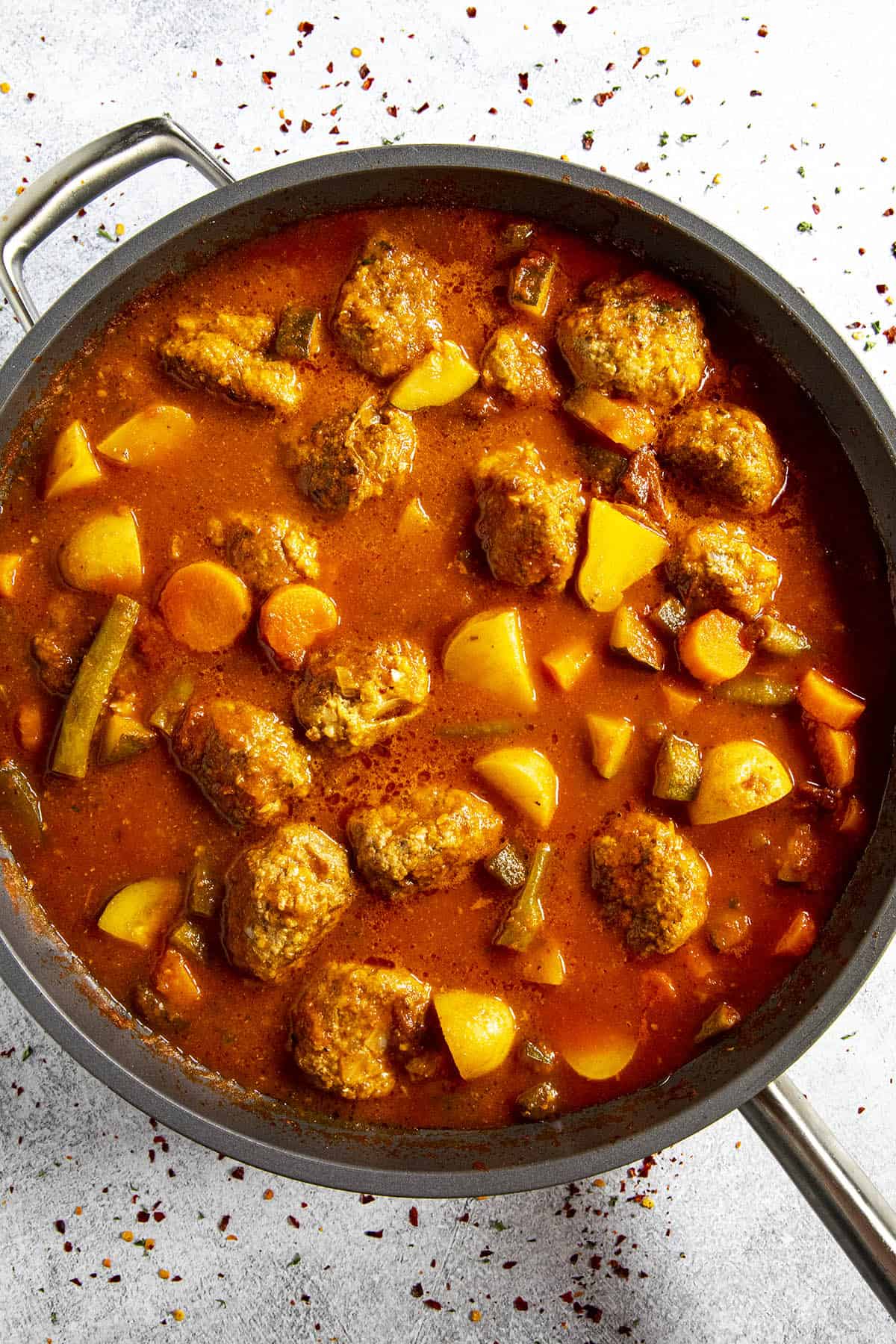 Simmering albondigas and vegetables in broth to make Albondigas Soup