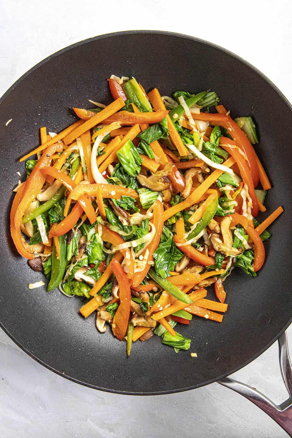 Cooking the vegetables and greens in a hot pan