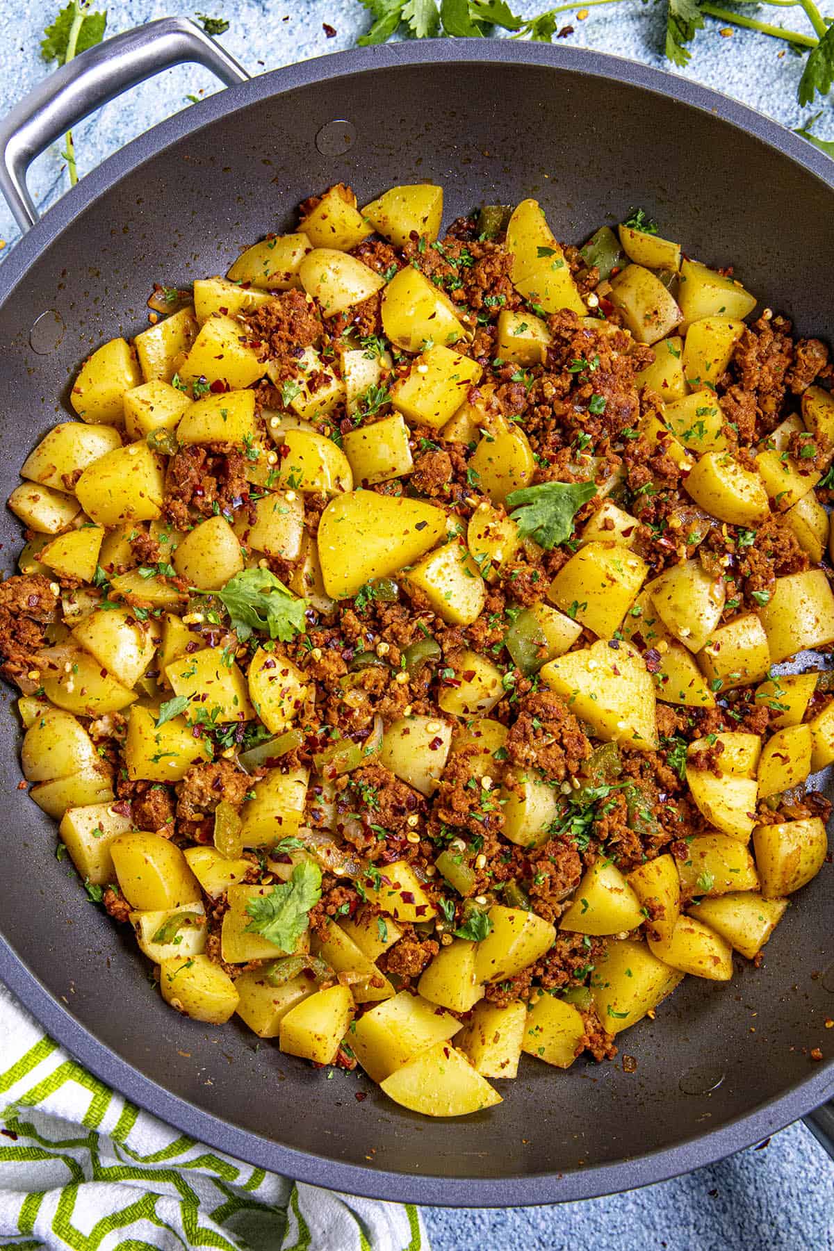 Spicy Papas con Chorizo with fresh herbs for garnish