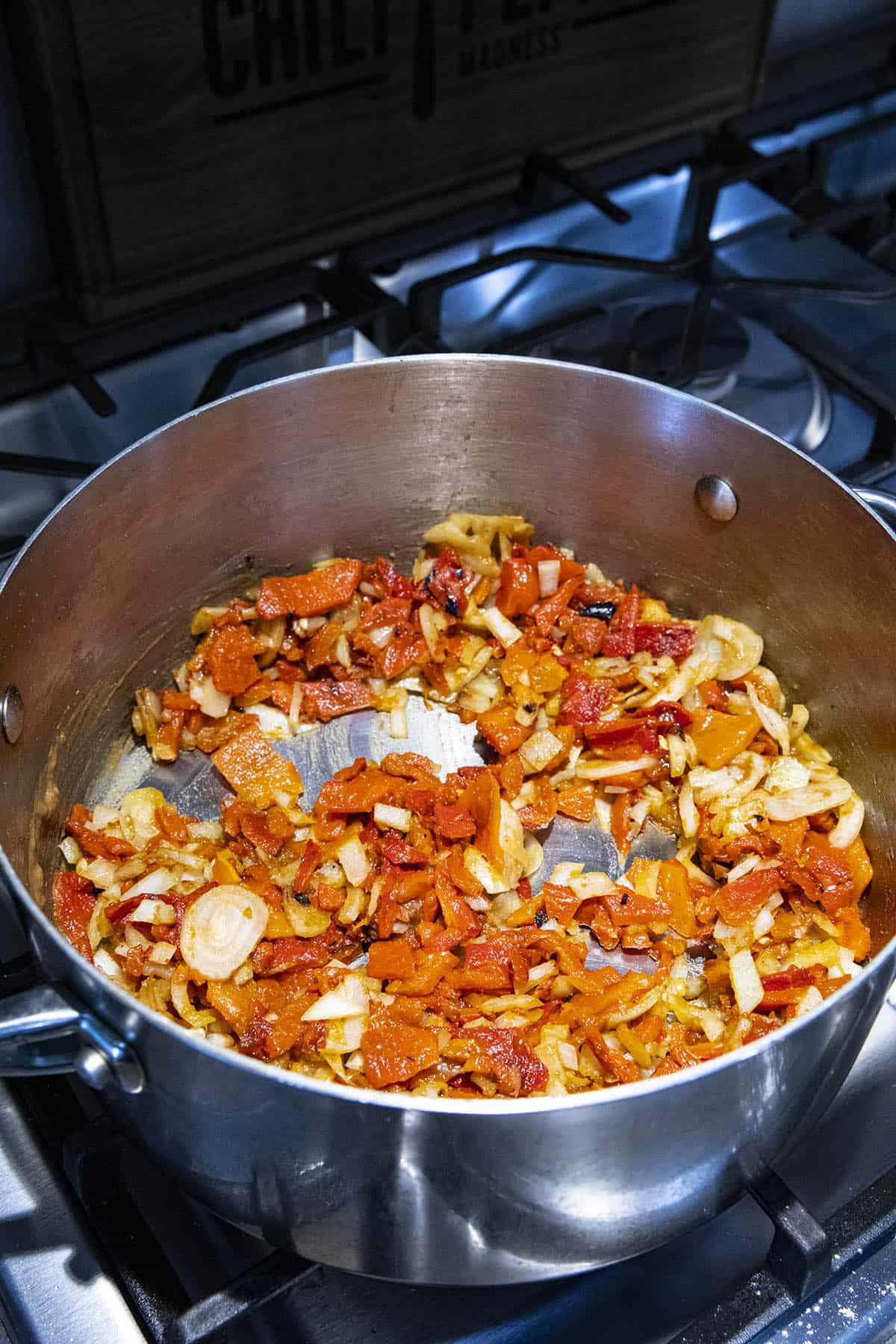 Cooking roasted red peppers and onions in a pot