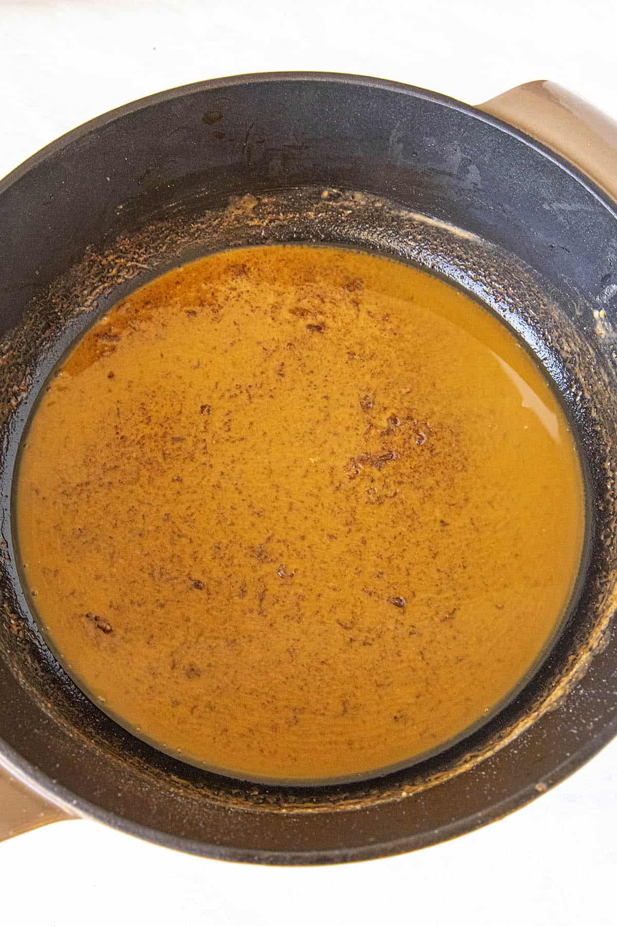 A dark roux in a pot for shrimp and grits
