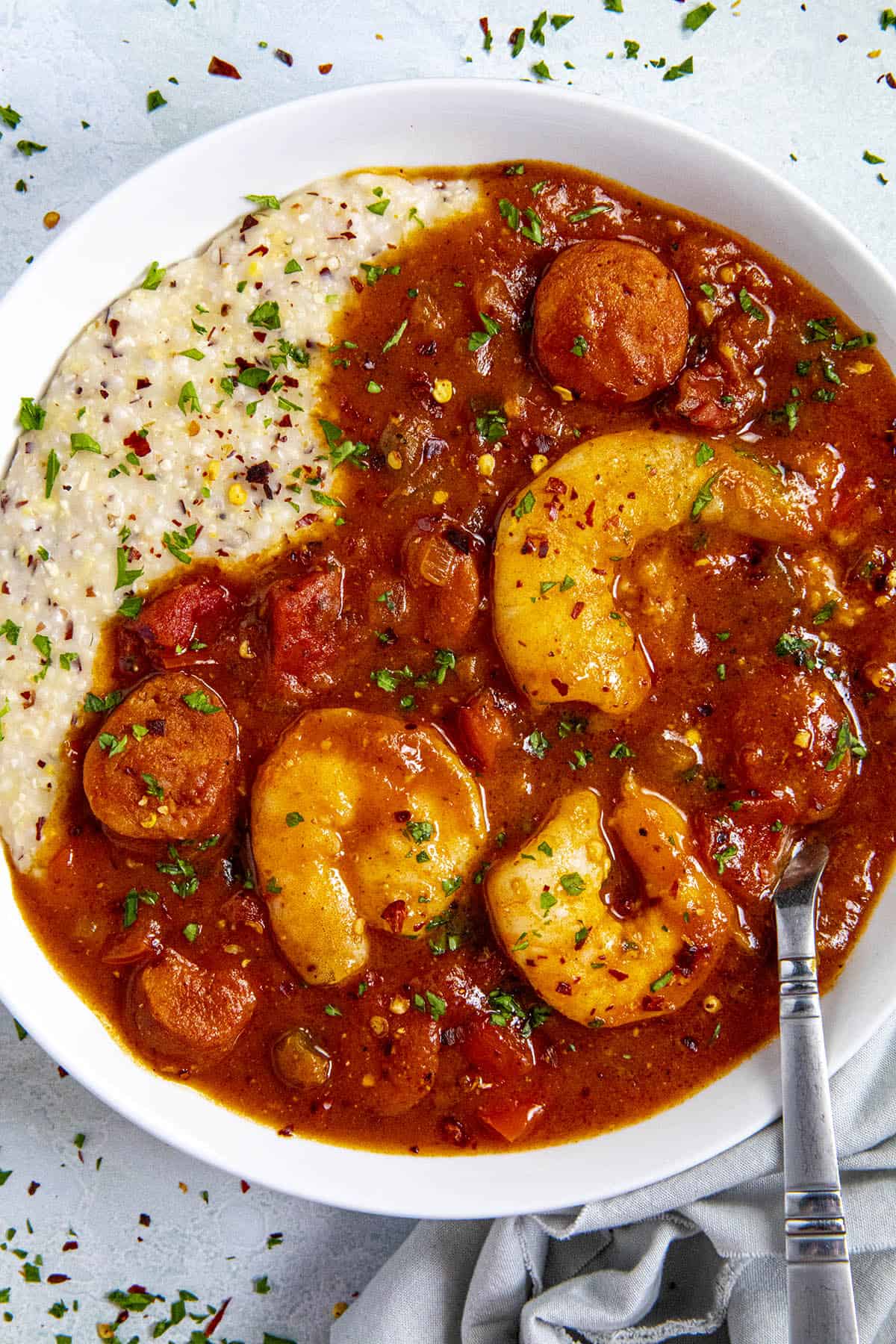 A bowl of Shrimp and Grits with fresh herbs and chili flakes