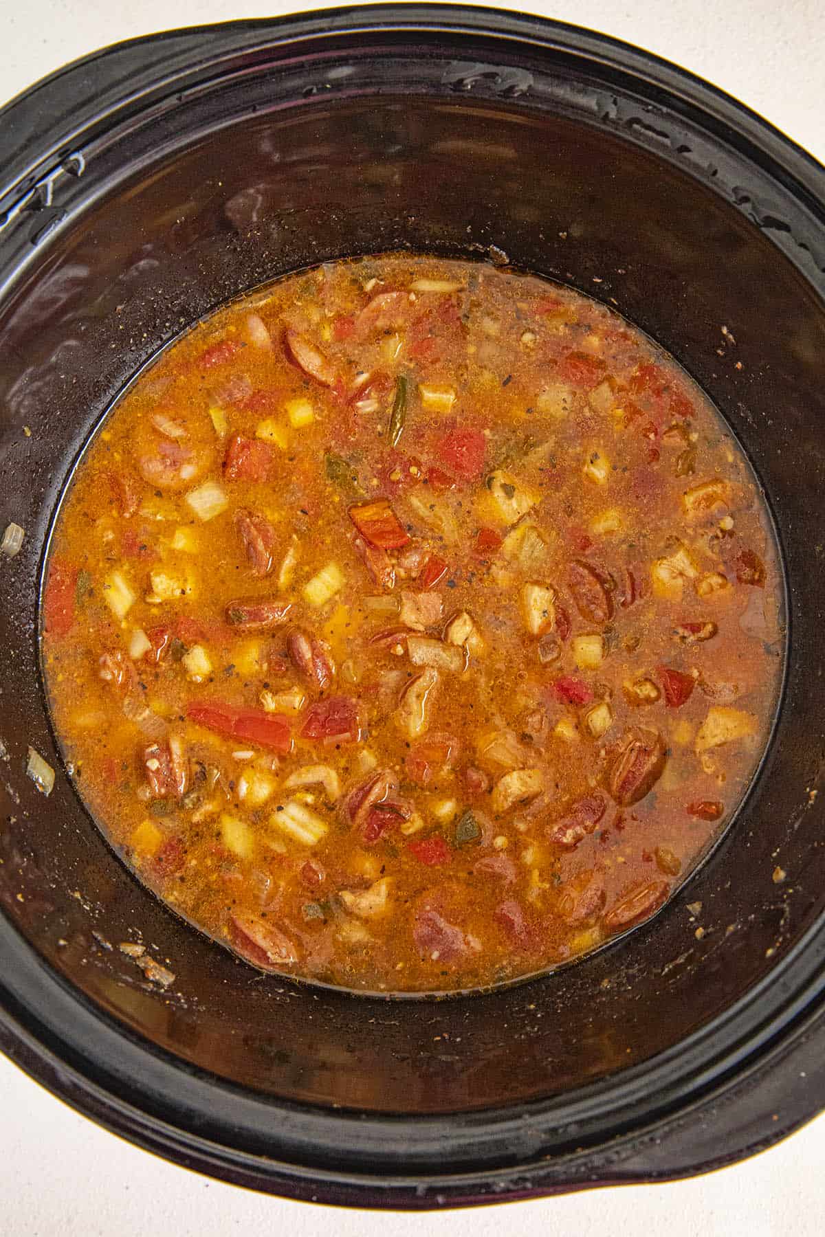 Adding stock and rice to the crockpot jambalaya