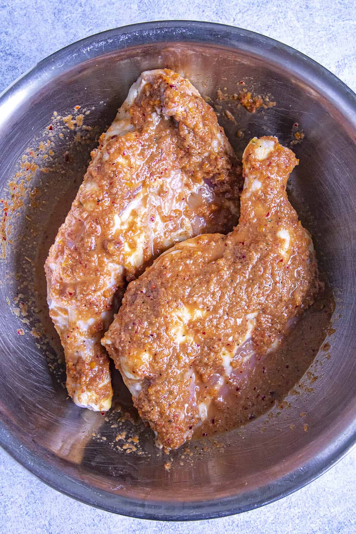 Marinating pieces of chicken to make Jerk Chicken