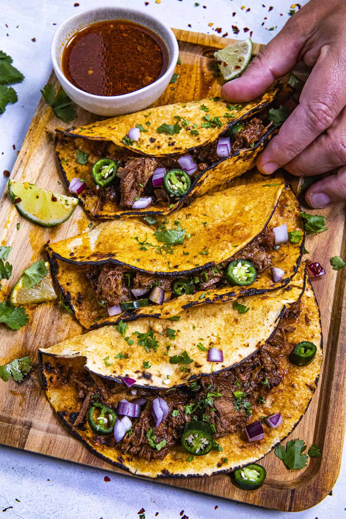 Mike taking Birria tacos from a platter