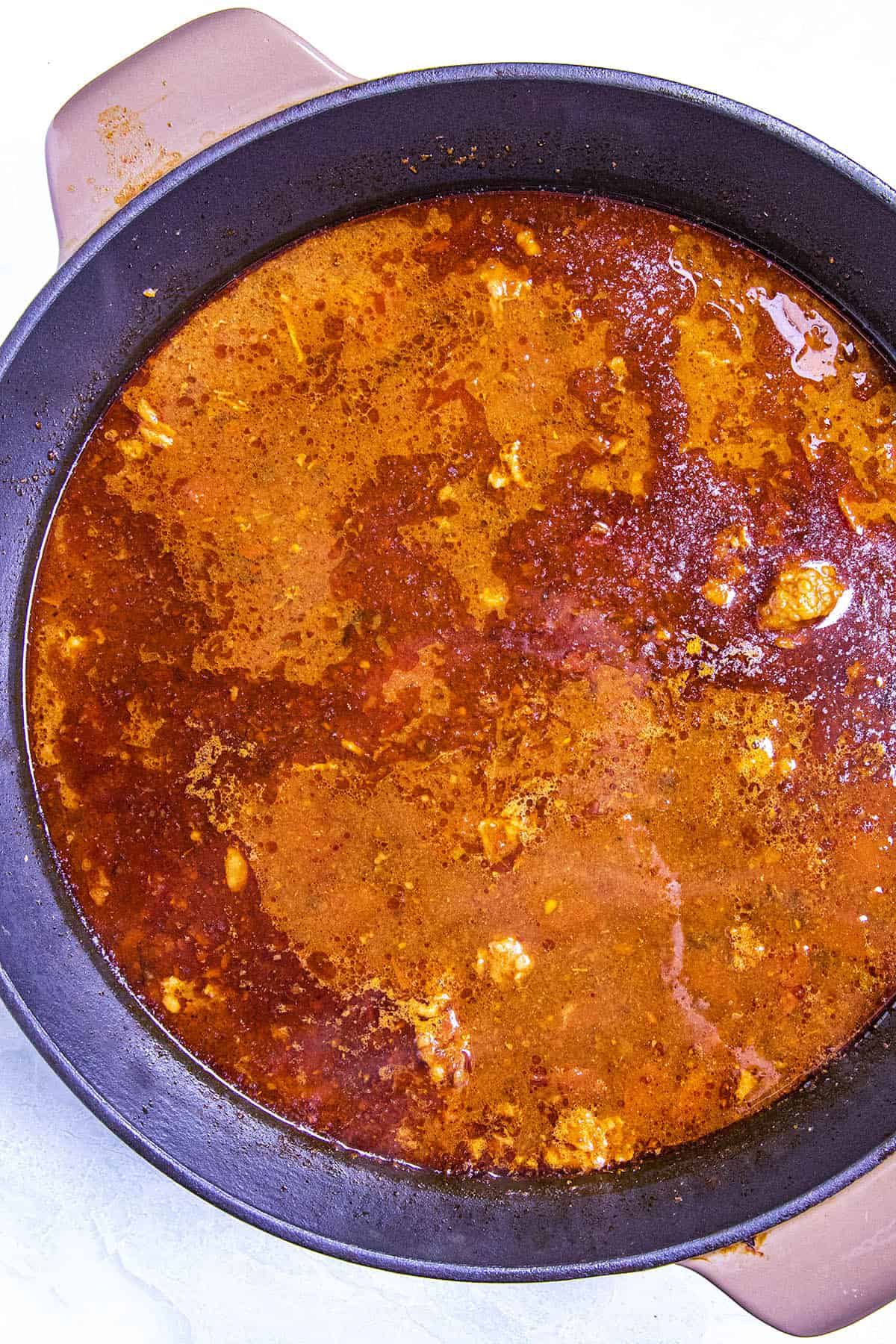 The first simmer of the meat in a large pot with chili paste and seasonings