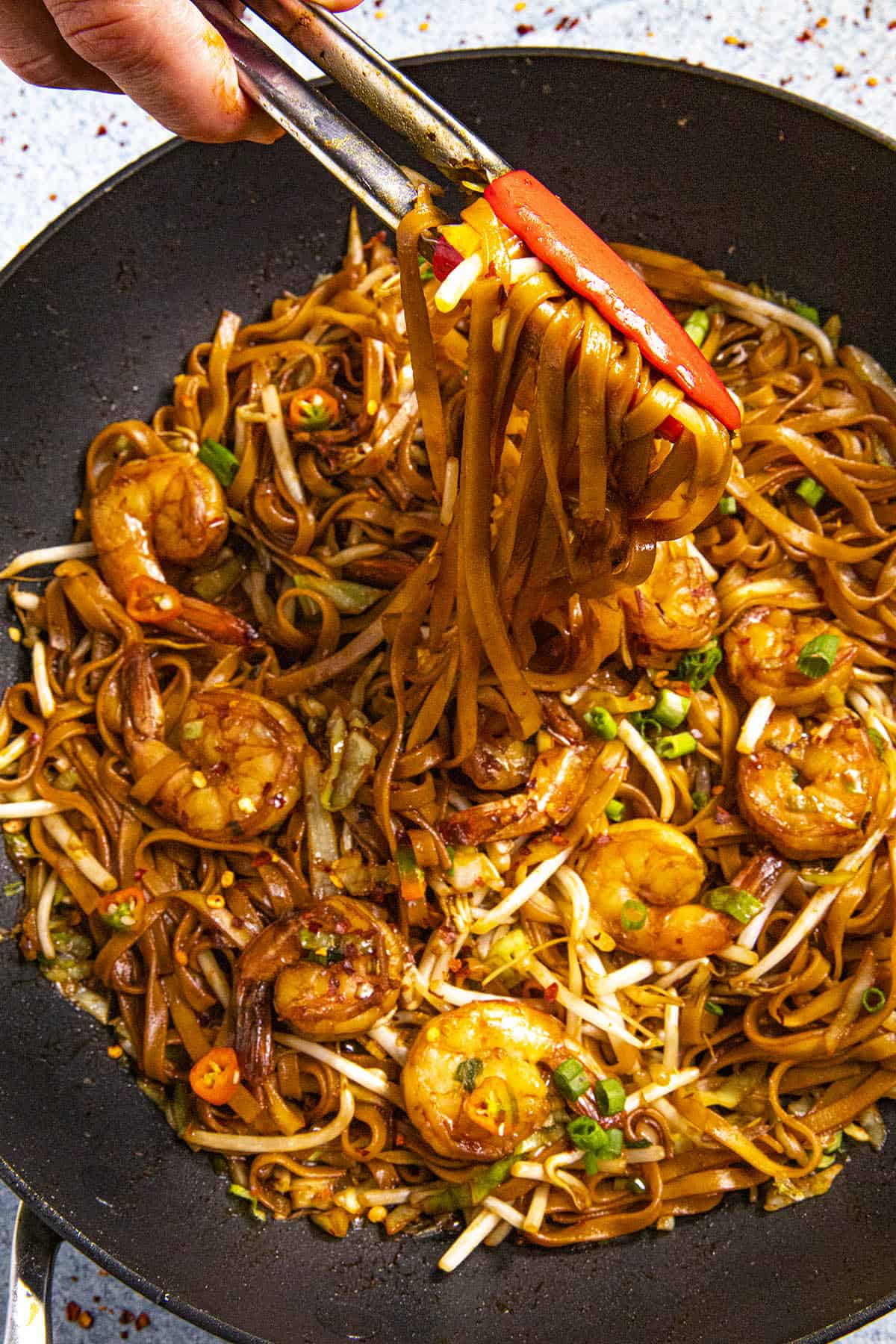 Mike scooping noodles of Mie Goreng, Indonesian stir fry noodles, from the pan