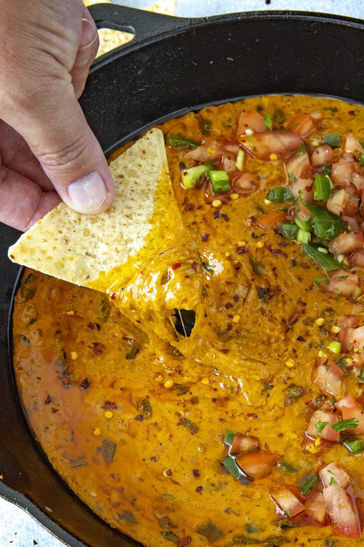 Gooey, cheesy Queso Fundido on a chip