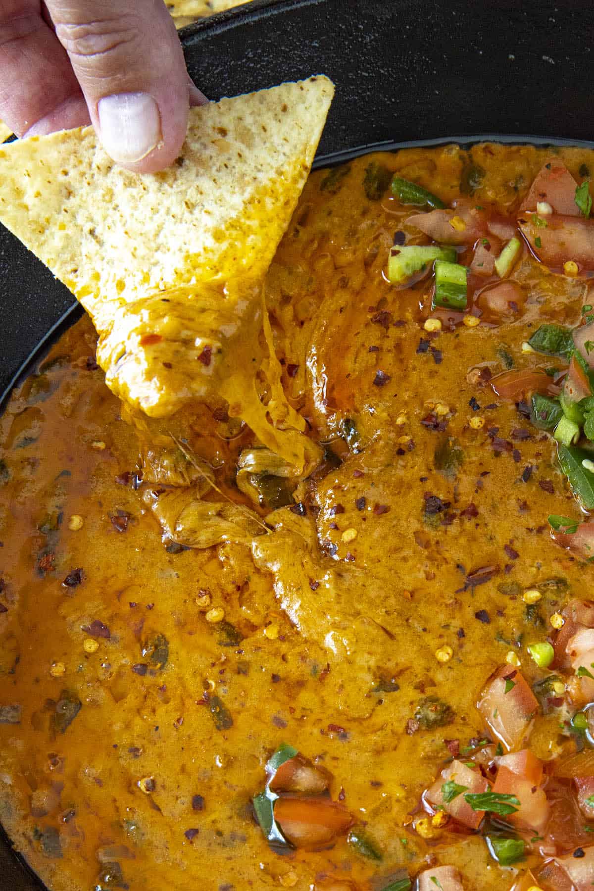 Mike taking a scoop of queso fundido from the pan