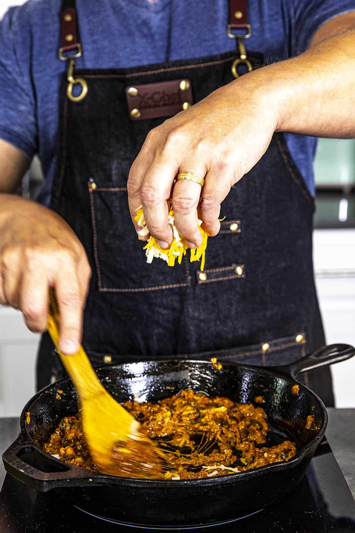 Mike swirling cheese into the hot pan to make queso fundido