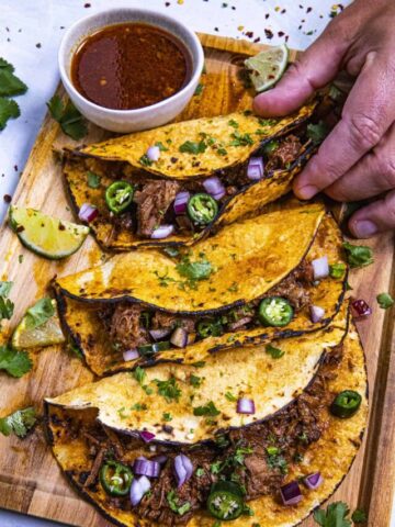 Mike taking Birria tacos from a platter