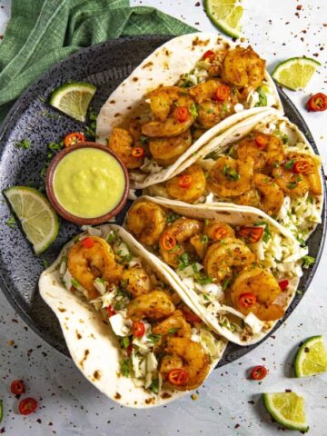 Shrimp Tacos on a plate with extra jalapeno sauce