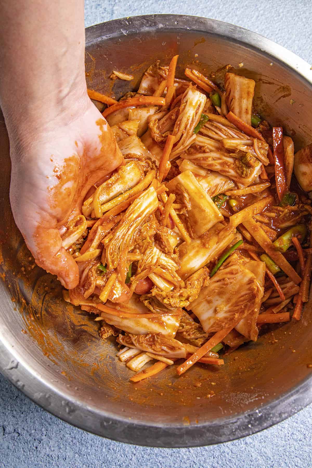 Mike mixing the kimchi sauce into the napa cabbage and other ingredients