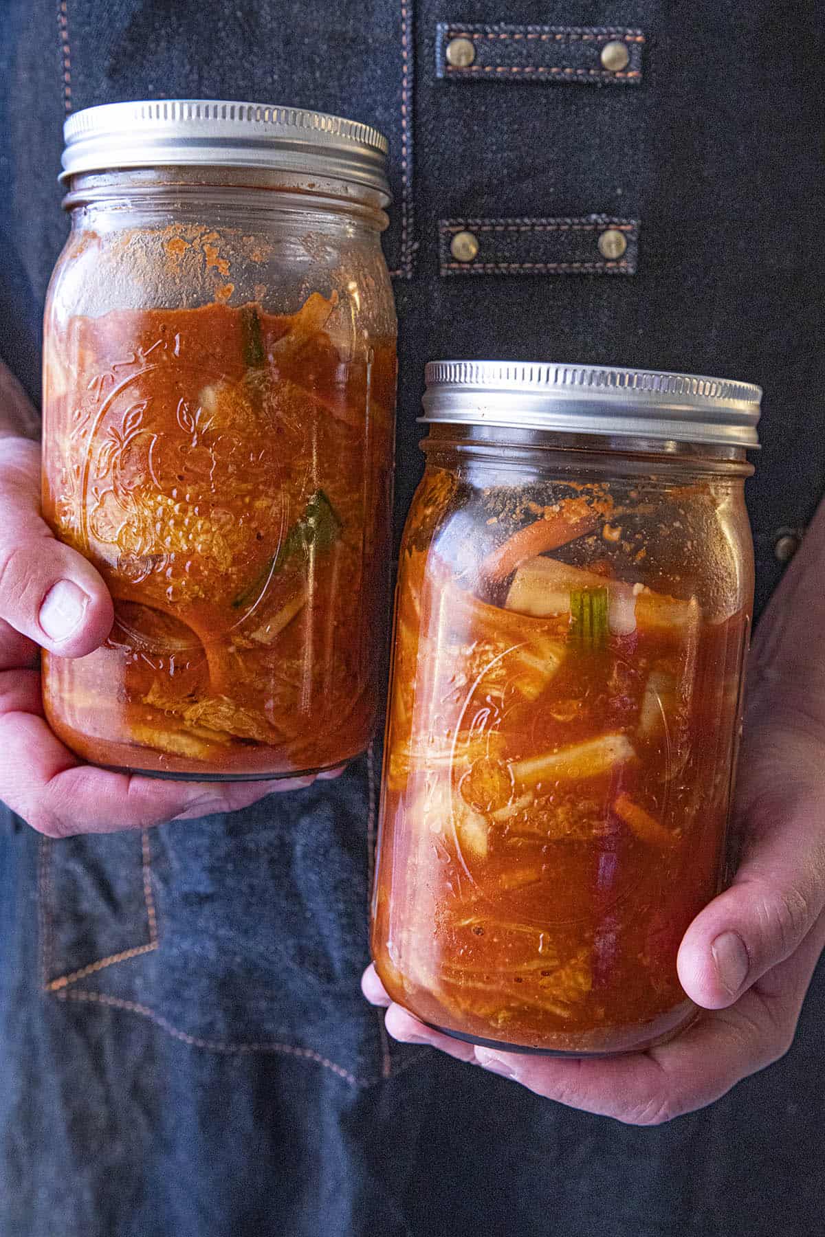 Mike holding 2 jars of spicy homemade kimchi