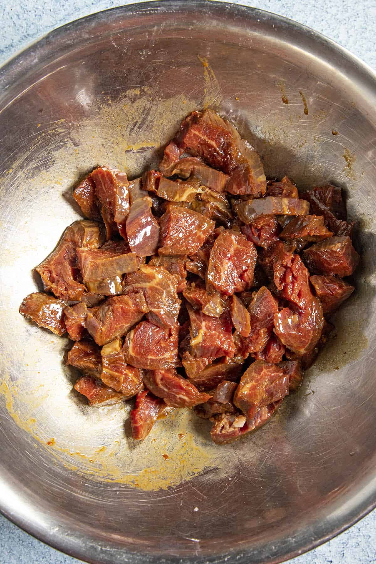 Marinating the chopped beef in a bowl