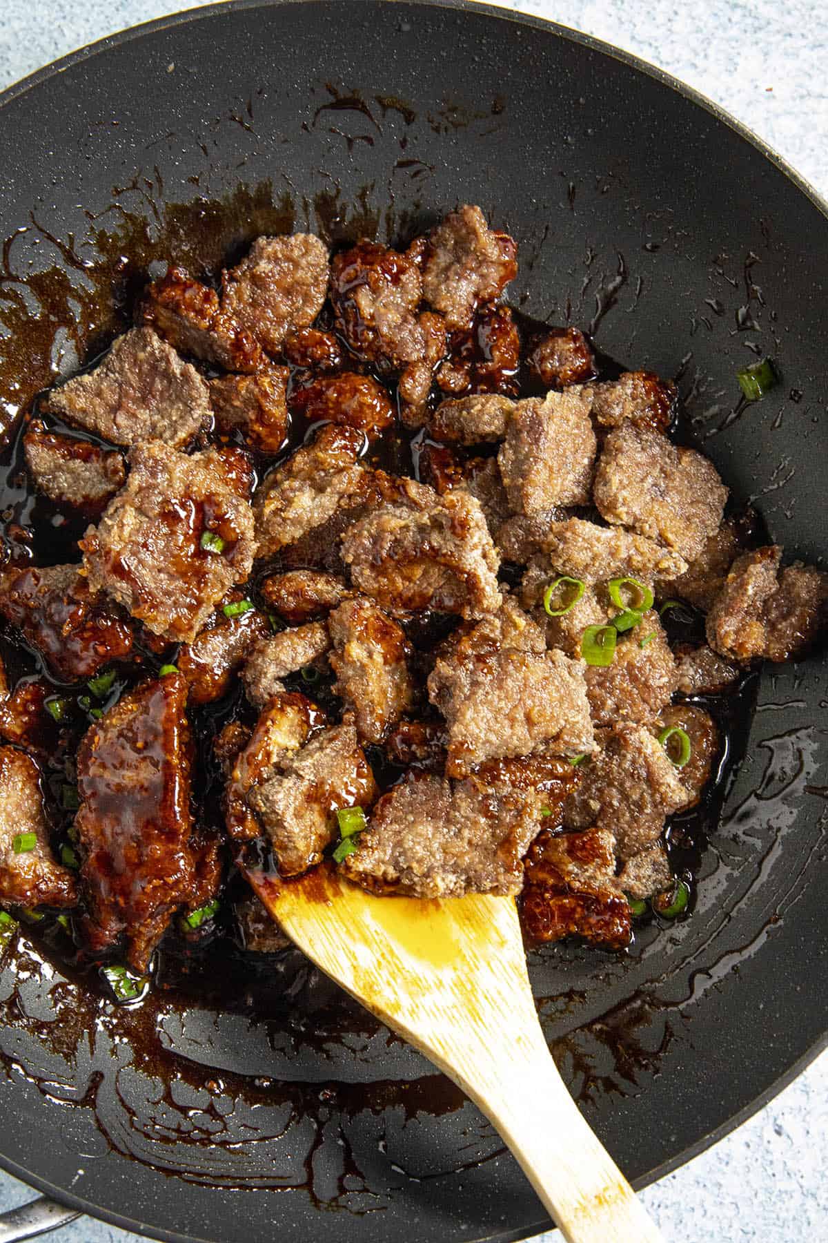 Mixing the beef into the Mongolian Beef sauce in the hot wok