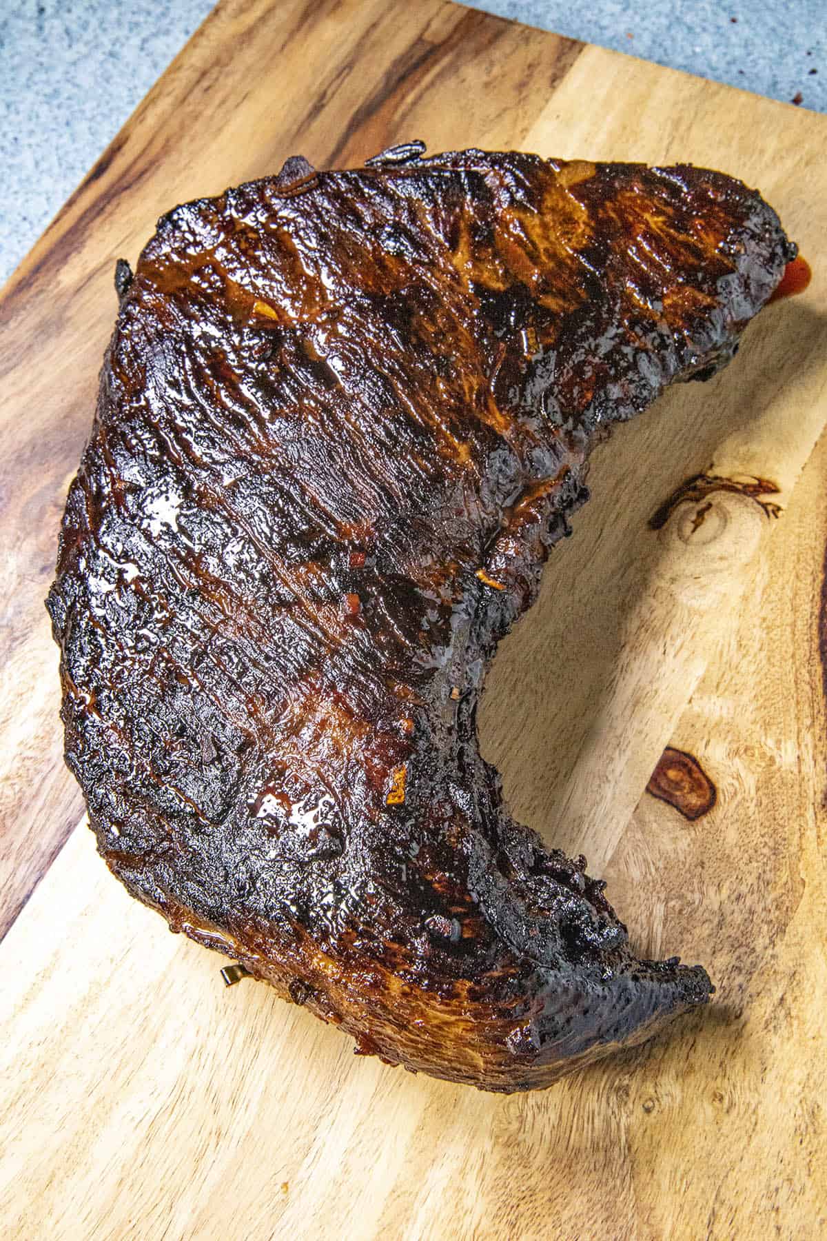 Marinated, oven roasted tri tip resting on a cutting board